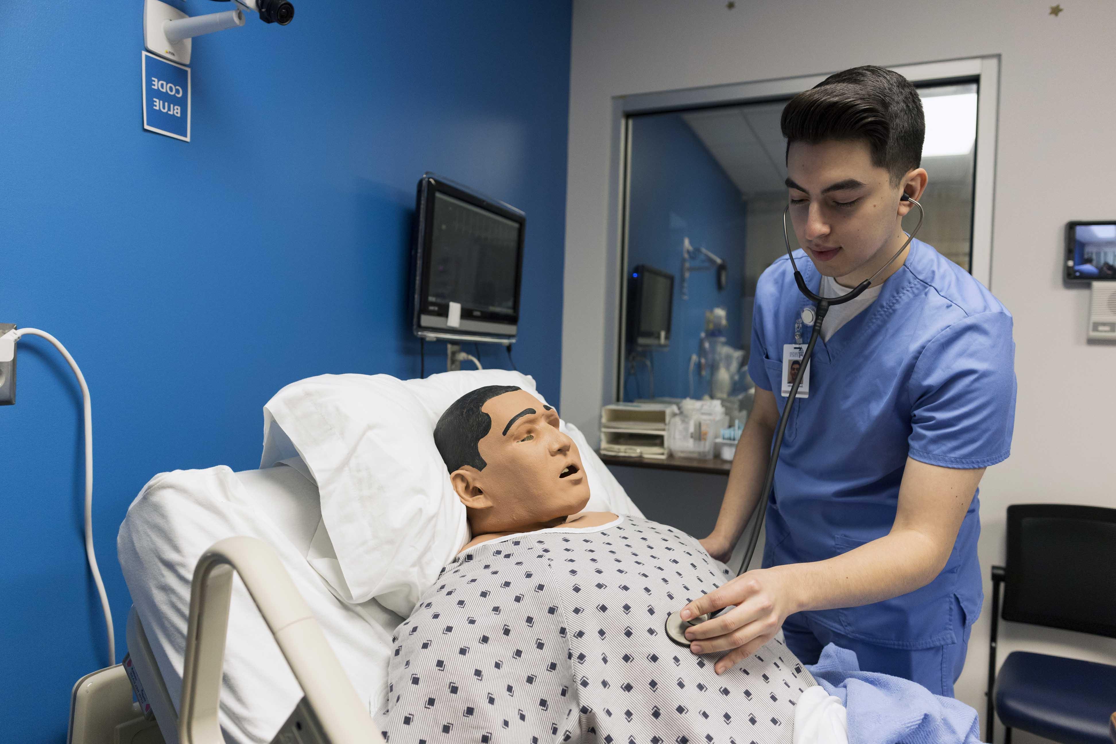 Health profession student getting vitals from mannequin